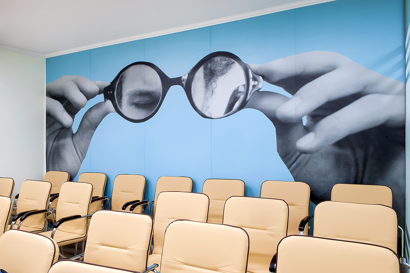 Stor collage af Sergei Sviatchenko dækker væggen bag en masse stole