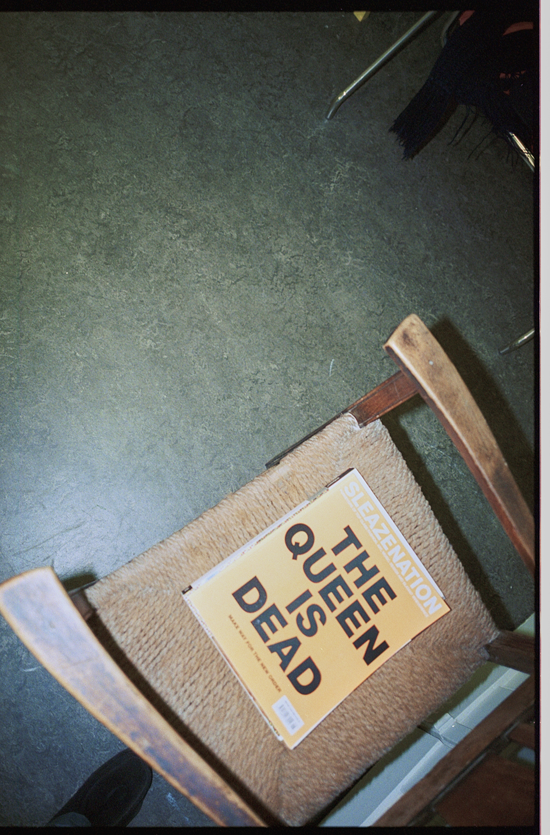 En stol hvorpå der ligger en bog med titlen 'The queen is dead'