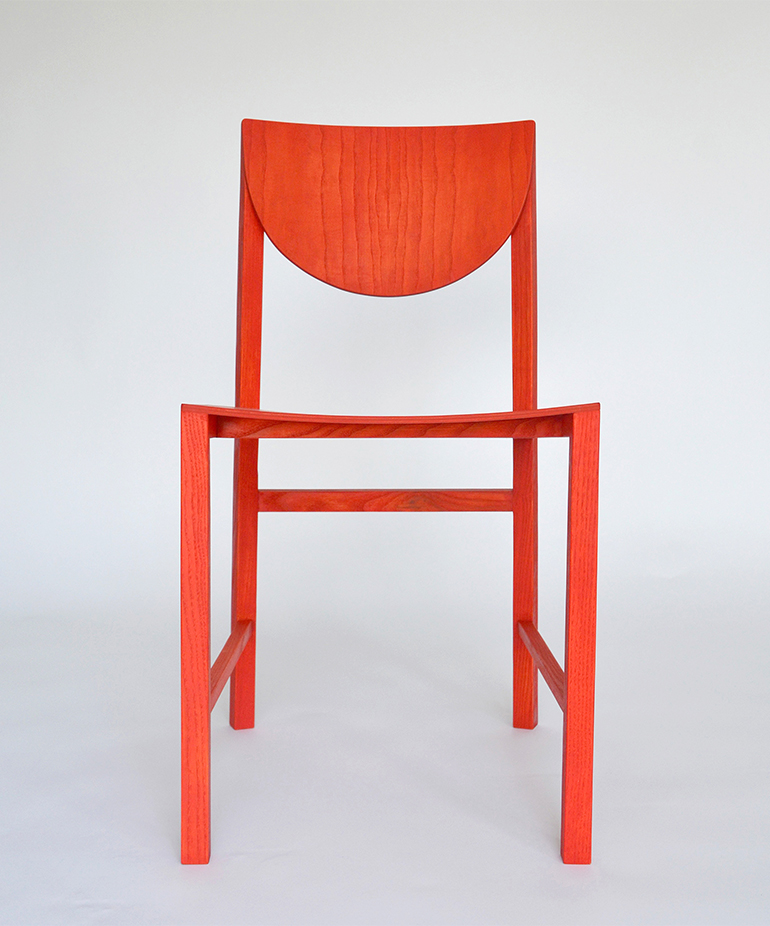 Prototype af en rød stol af træ, lavet af Mette Schelde
