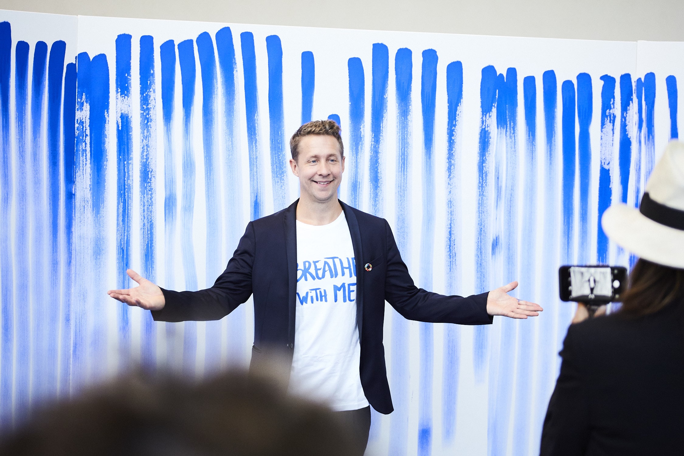 Jeppe Hein står foran stor kanvas med striber af blå maling fra BreatheWithMe