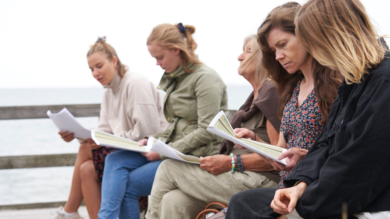 Fem kvinder læser sammen udenfor